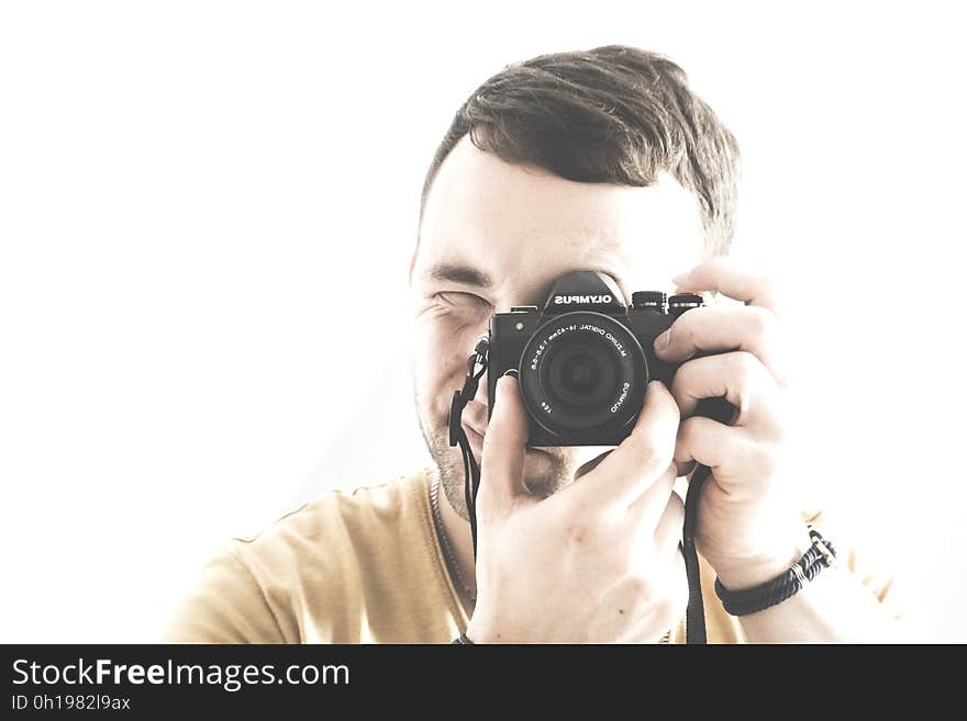 Portrait closeup of a young male adult looking through the viewfinder and adjusting the lens of his camera, isolated on a white background. Portrait closeup of a young male adult looking through the viewfinder and adjusting the lens of his camera, isolated on a white background.