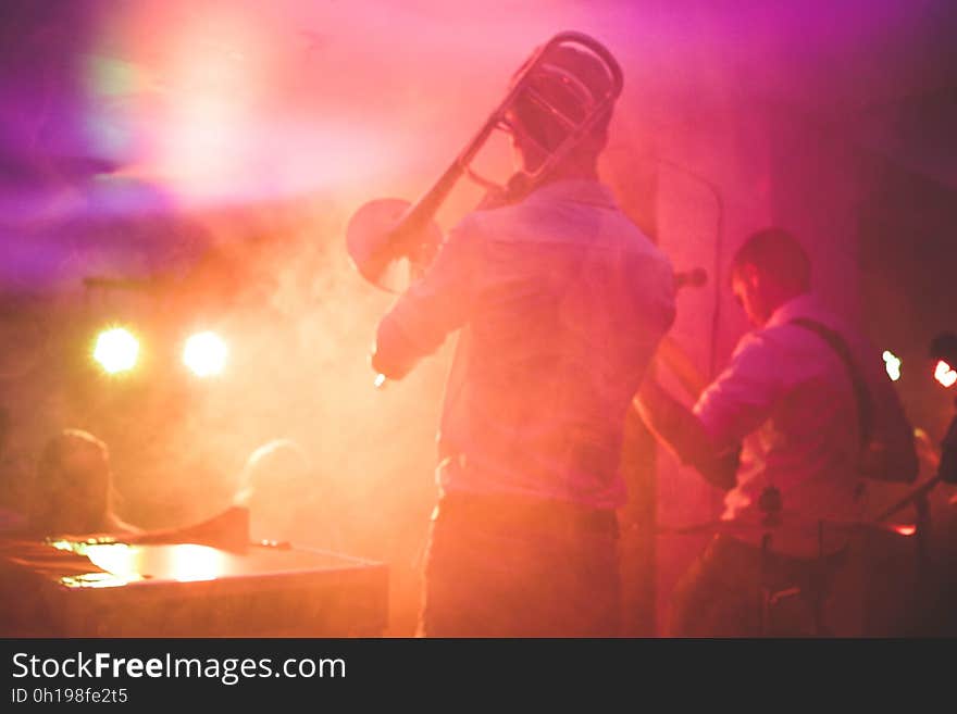 A band playing on a stage with colorful lights. A band playing on a stage with colorful lights.