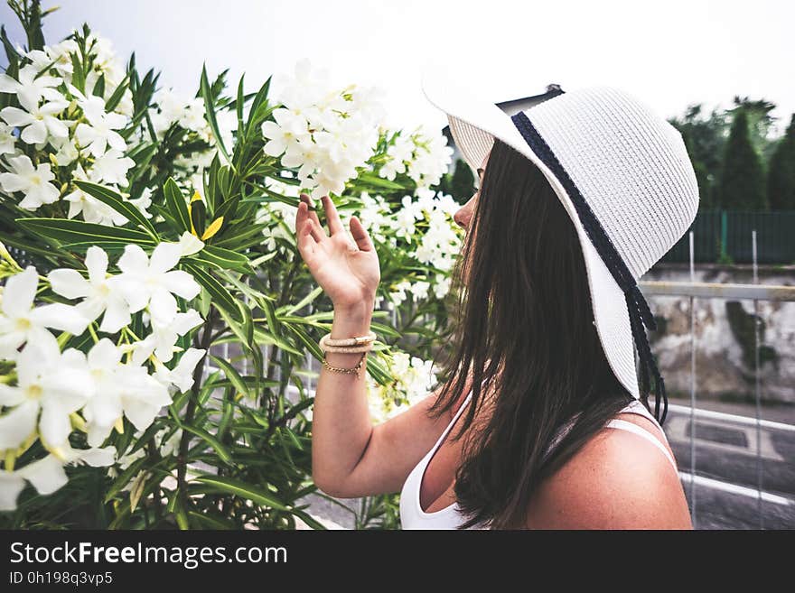 A woman smelling Nerium oleander flowers.