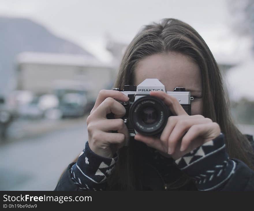 Woman Wearing White and Black Coat Holding Black and Gray Digital Camera