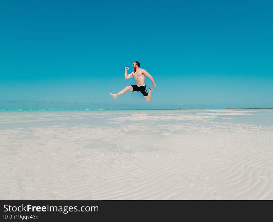 Full Length of a Man Jumping from Beach