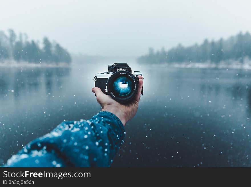 Reflection of Man Photographing in Snow