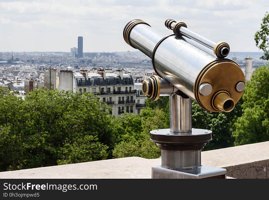 Gray and Brown Tower Telescope Near Trees and High Rise Buildings