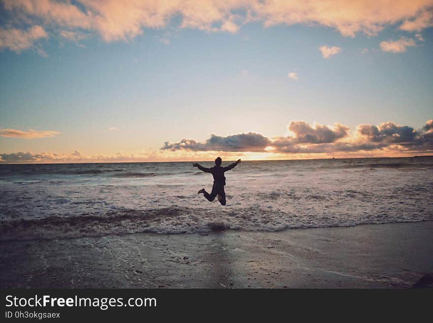 Person Taking Picture in Seashore during Sunset