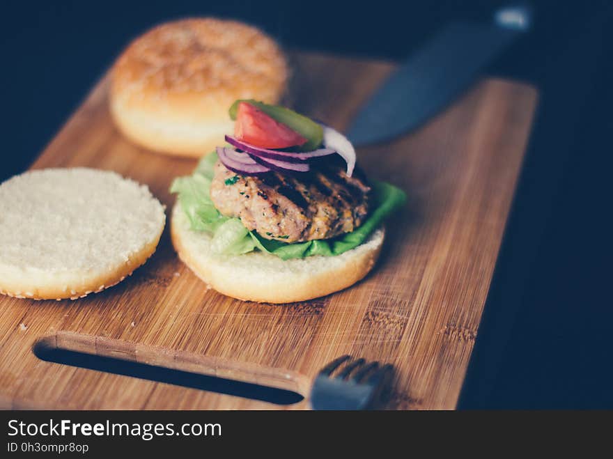 Shallow Focus Photography of Burger Sandwich Served on Brown Wooden Chopping Board