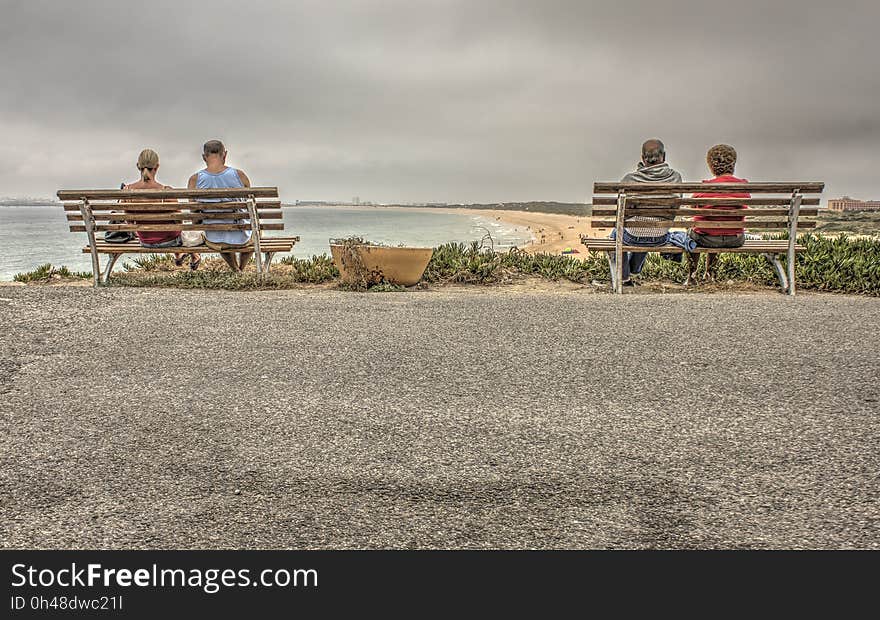 Two Couple Sitting on Bench Near Beach