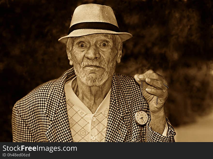 Grayscale Photo of a Man in Houndstooth Print Suit Jacket Wearing a Hat