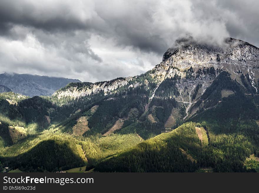 Green Grass Beside Black and White Mountain during Daytime