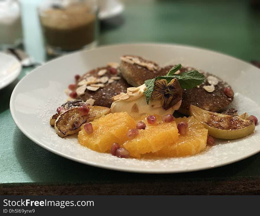 A close up of a plate of fruits, ice cream and nuts. A close up of a plate of fruits, ice cream and nuts.