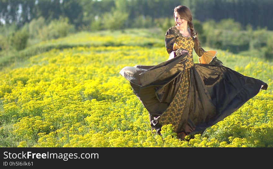 Woman Wearing Black and Brown Dress Standing on Green Grass during Daytime