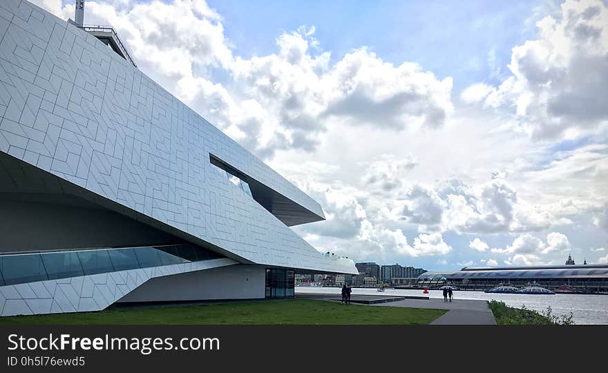 Low Angle View of White Concrete Structure Under White Cloudy Sky at Daytime