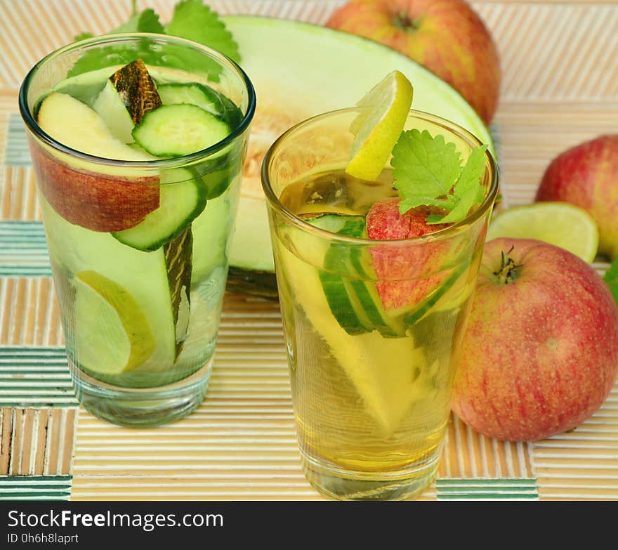 Clear Glass Cup With Fruits and Water Inside Beside Slice Fruitas