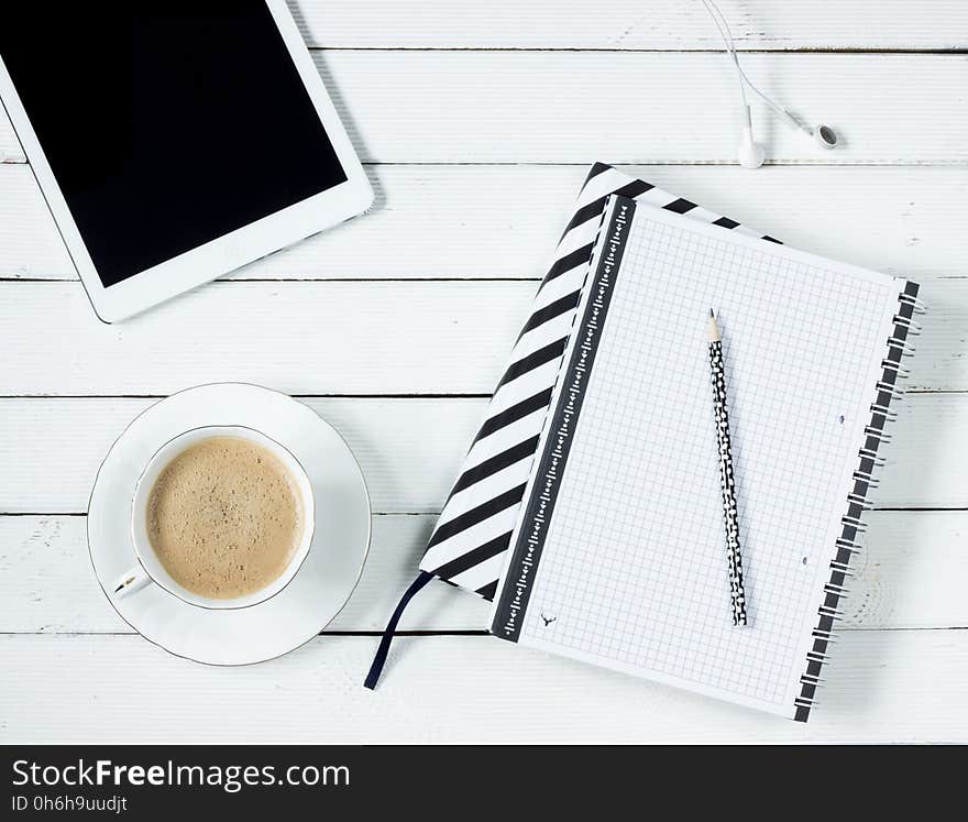 White Tablet Computer Beside White Notebook