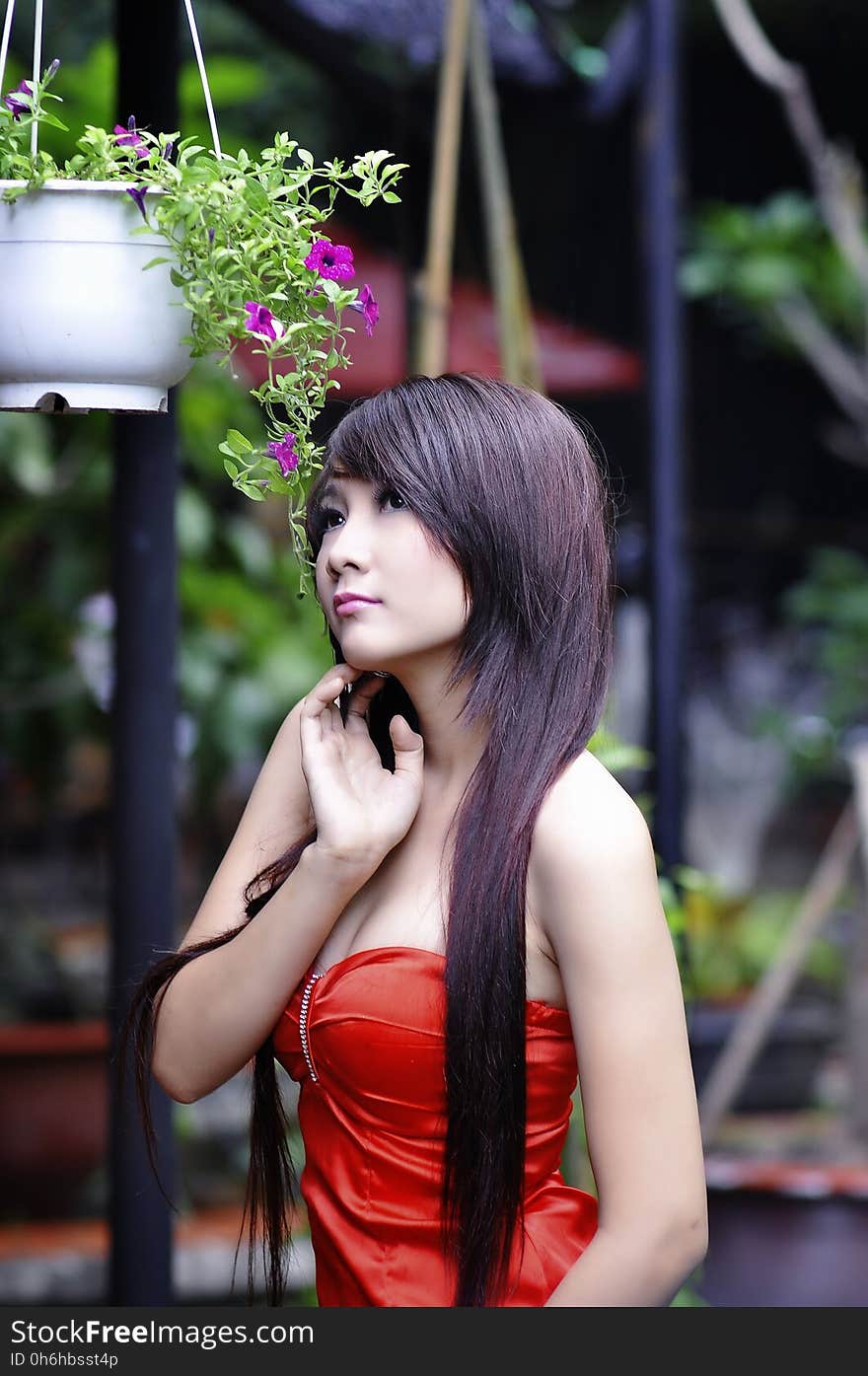 Woman Wearing Red Sweet Heart Neckline Dress Standing Near Hanging Flower Vase