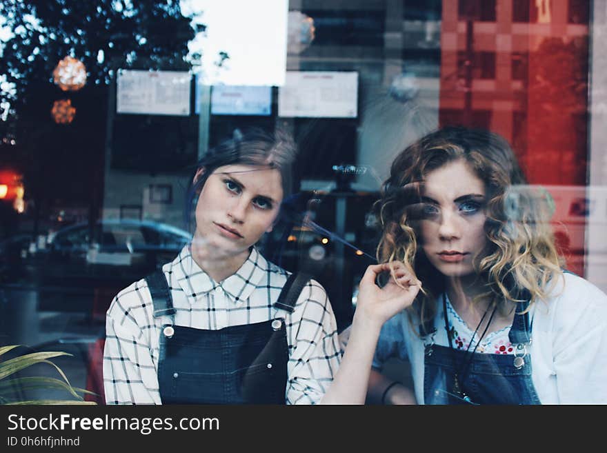 2 Woman in Blue Overalls Sitting Inside Store during Daytim