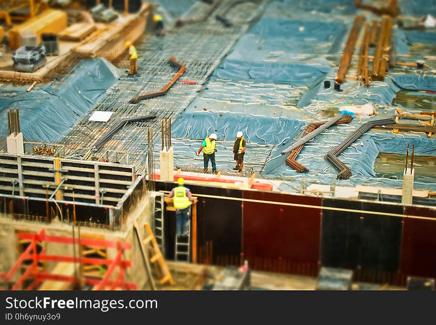 Man in Yellow Safety Vest Climbing on Ladder