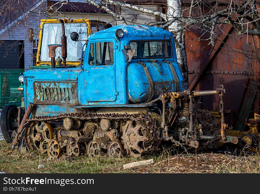 Blue caterpillar tractor rusting under the open sky. Blue caterpillar tractor rusting under the open sky