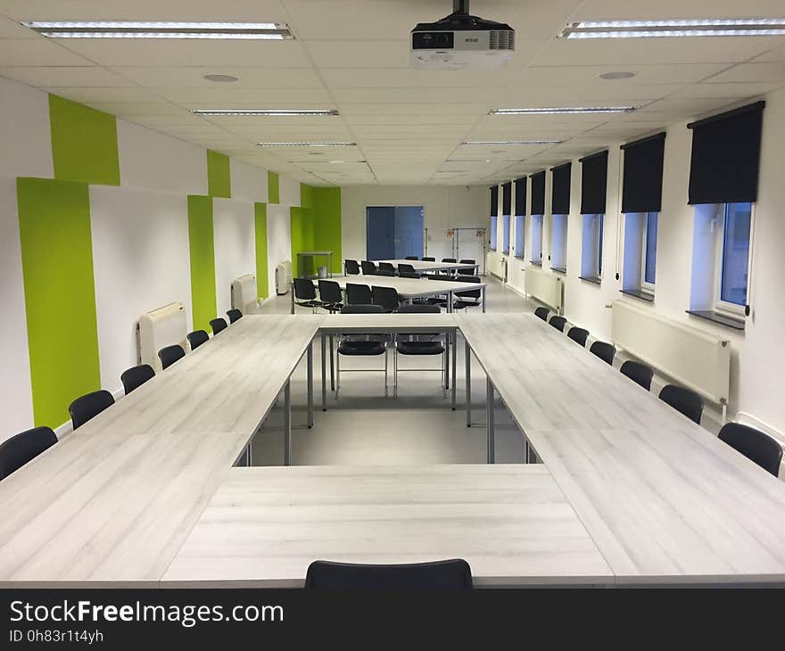 White Wooden Table and Black Chairs Inside White Green Painted Room