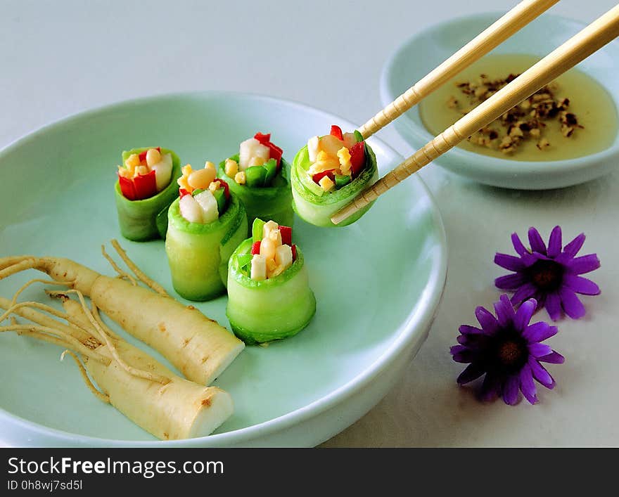 Vegetable Covered With Food Wrapper on Green Bowl With Chopstick Beside Purple Flower