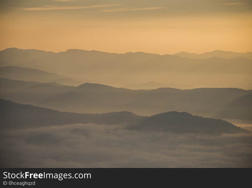 Layer of mountains and mist during sunset