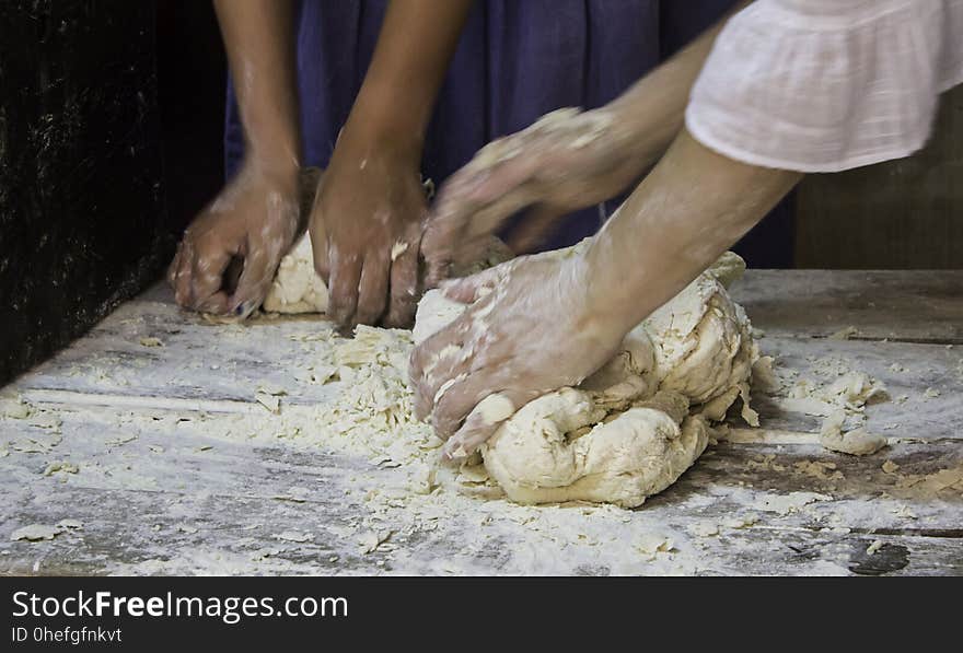 Bakers kneading bread dough in traditional way, artisan work detail, daily meal, healthy living. Bakers kneading bread dough in traditional way, artisan work detail, daily meal, healthy living