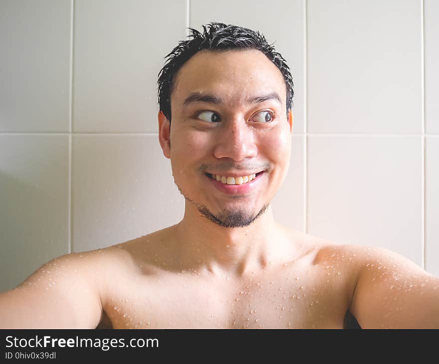 Happy man taking selfie in bathroom.