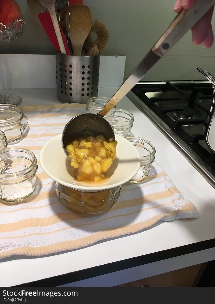 Filling jars with peach jam