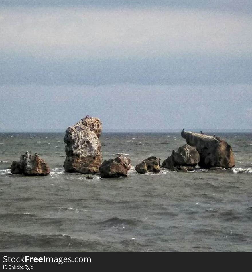 Rocks sticking out of the water on the coast of the sea. Rocks sticking out of the water on the coast of the sea.