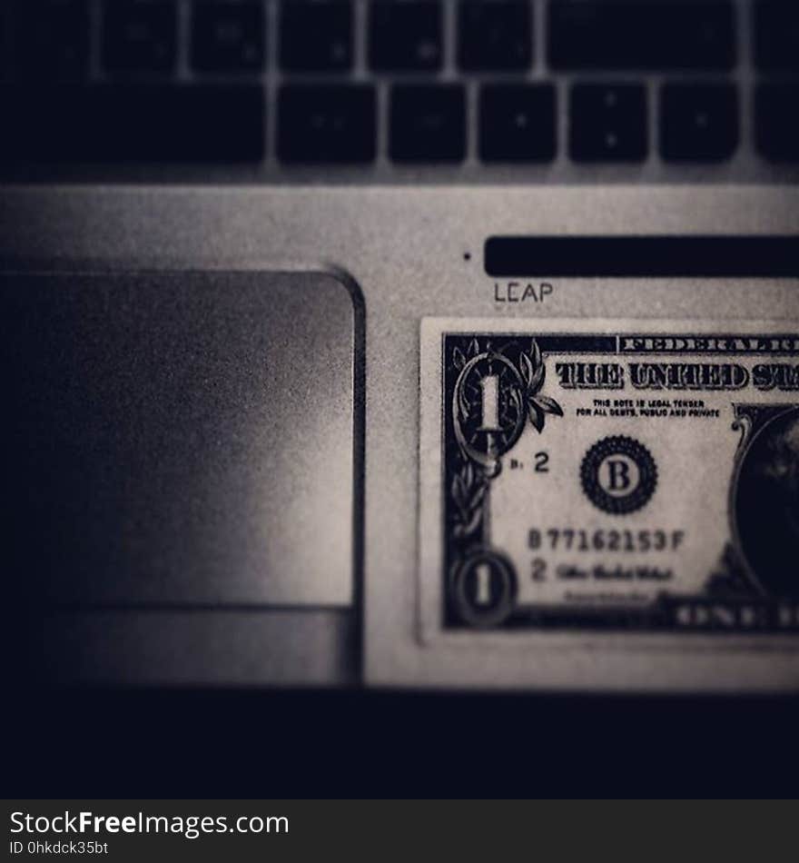 A dollar bill on a laptop keyboard. A dollar bill on a laptop keyboard.