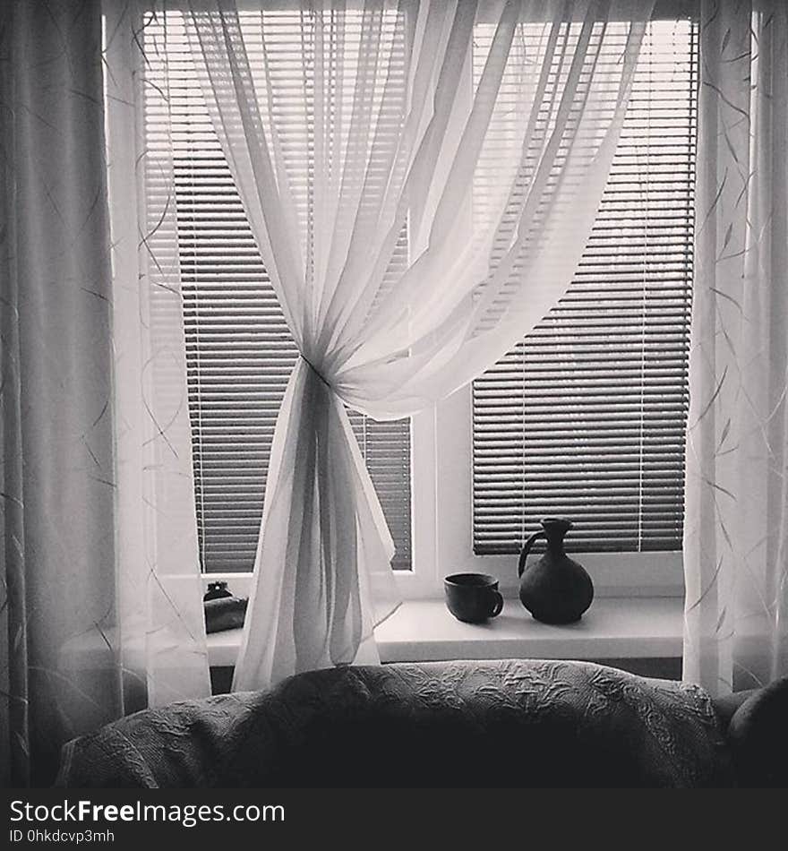 Black and white of curtains and blinds that are open in a home. Black and white of curtains and blinds that are open in a home.