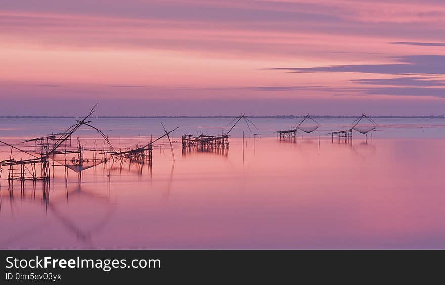 fishermen with yellow and orange sun in the background