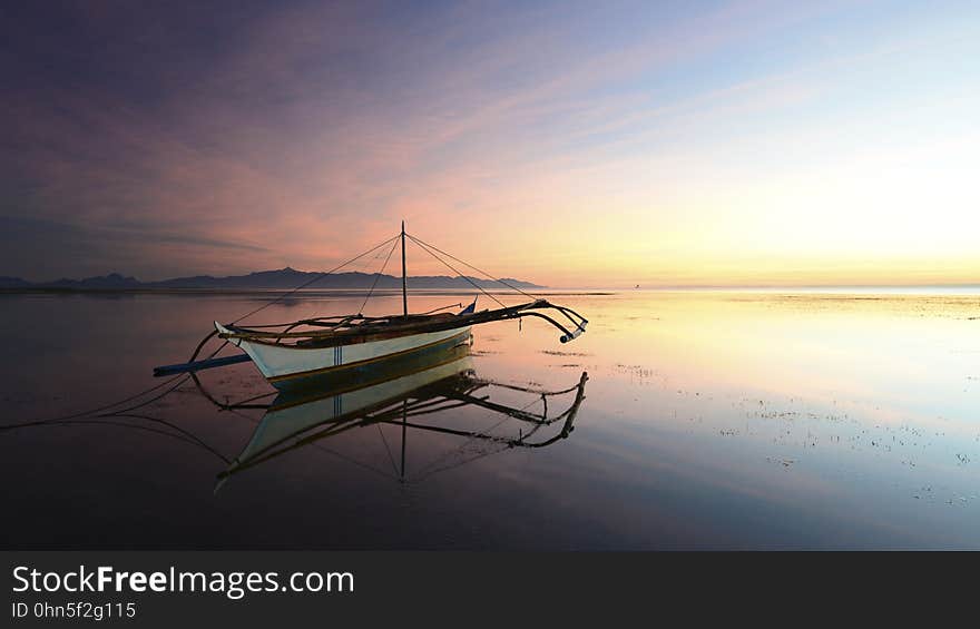 Boat reflecting in calm waters at sunset. Boat reflecting in calm waters at sunset.