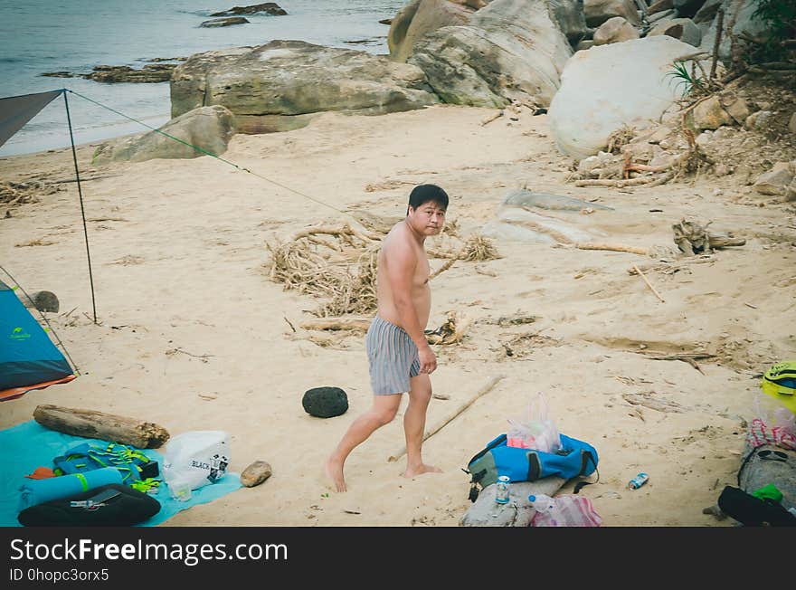 A boy near a camp on a beach. A boy near a camp on a beach.