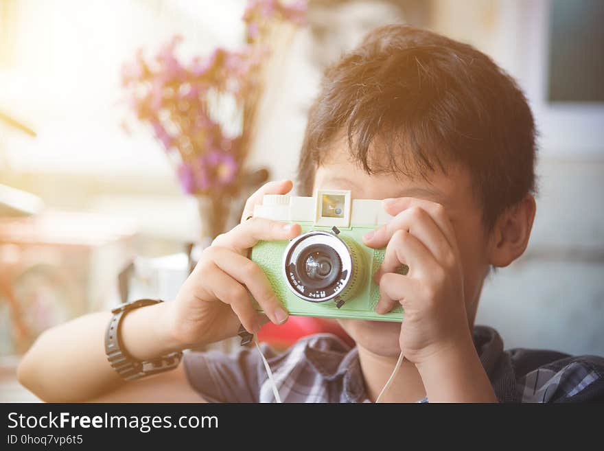 Boy Taking Photo By Classic Camera With Vintage Filt