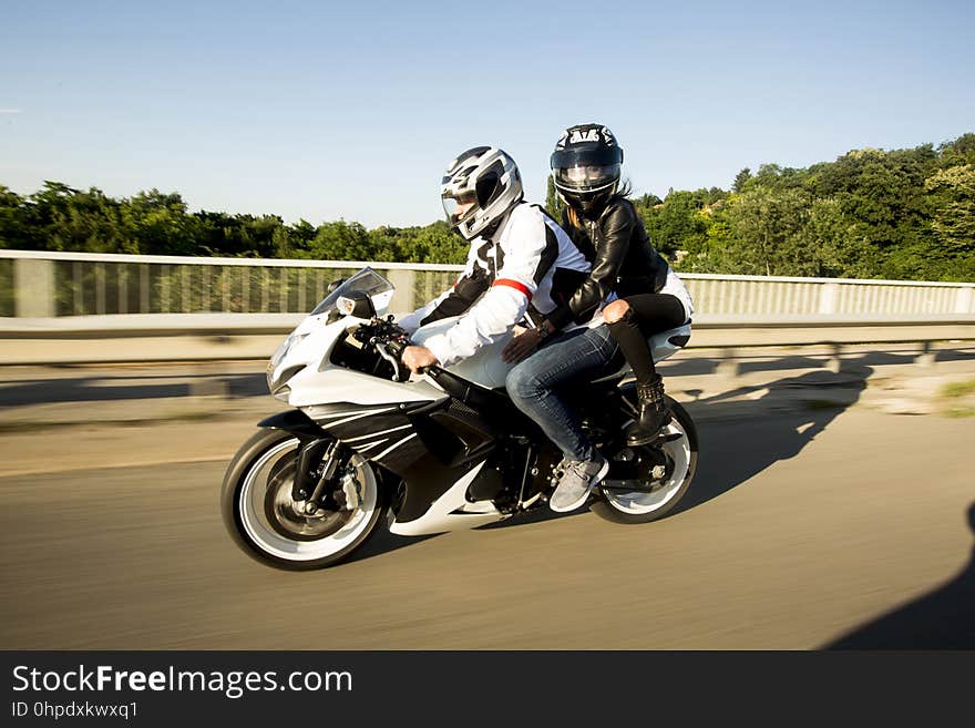 Young men and a women on a motorcycle by day. Young men and a women on a motorcycle by day