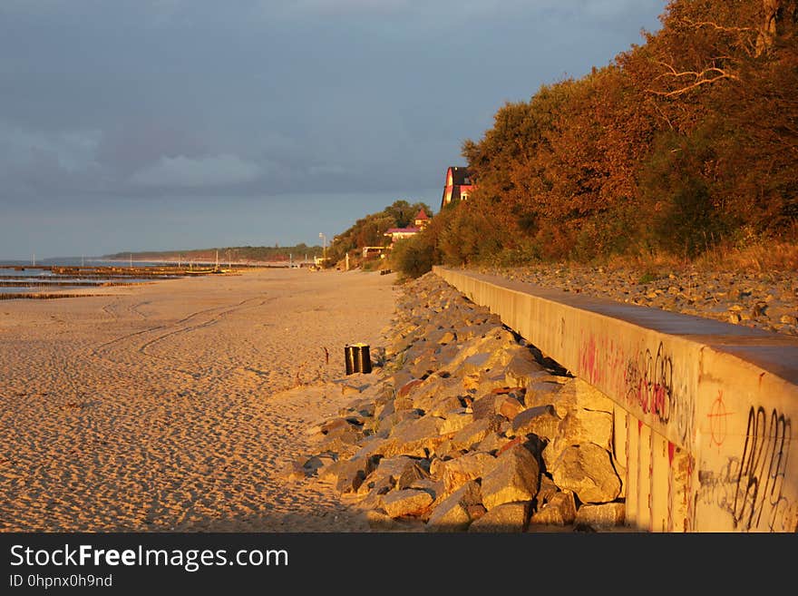 A long sandy beach with rocks.