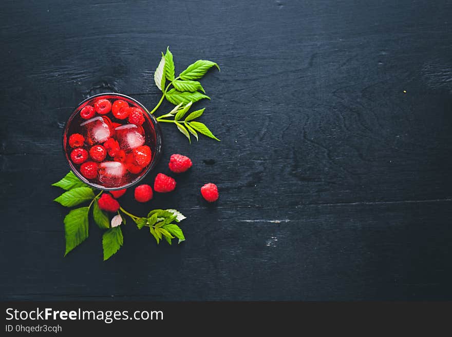 Cocktail of fresh raspberries with ice, on a wooden background