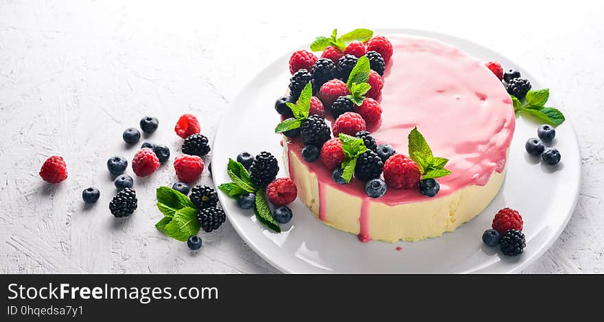 Cake with butter and fresh berries and fruits. Dessert. On a wooden background