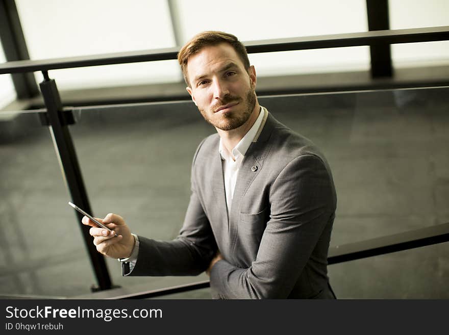 Happy smiling urban businessman using smart phone outside