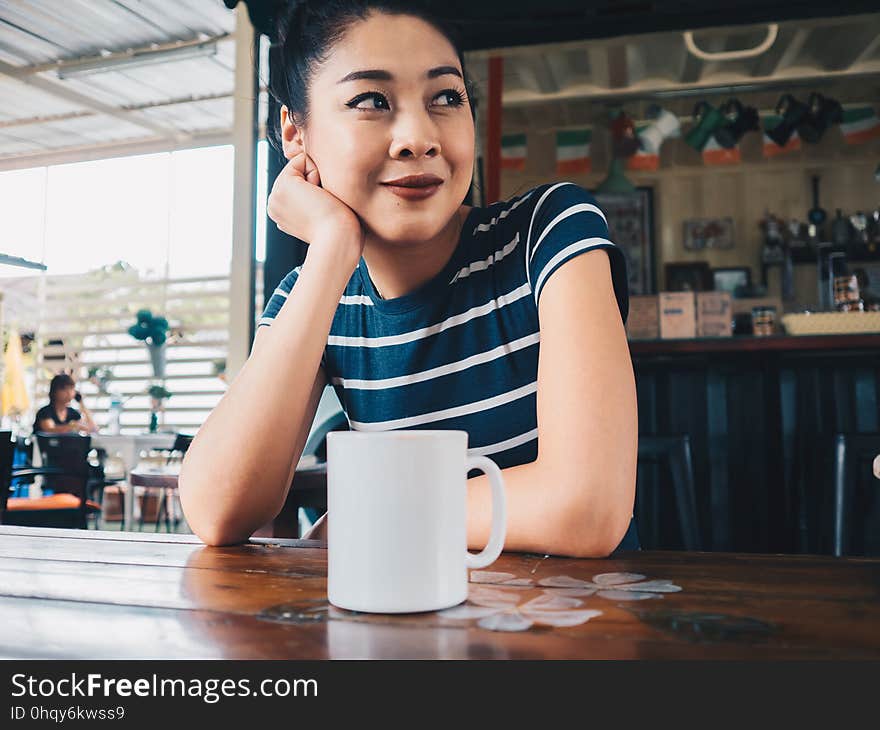 Happy woman drinking coffee in coffee cafe.