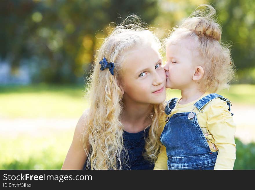 Sisters. Relations. Daughters. Portrait children. Kiss. Love