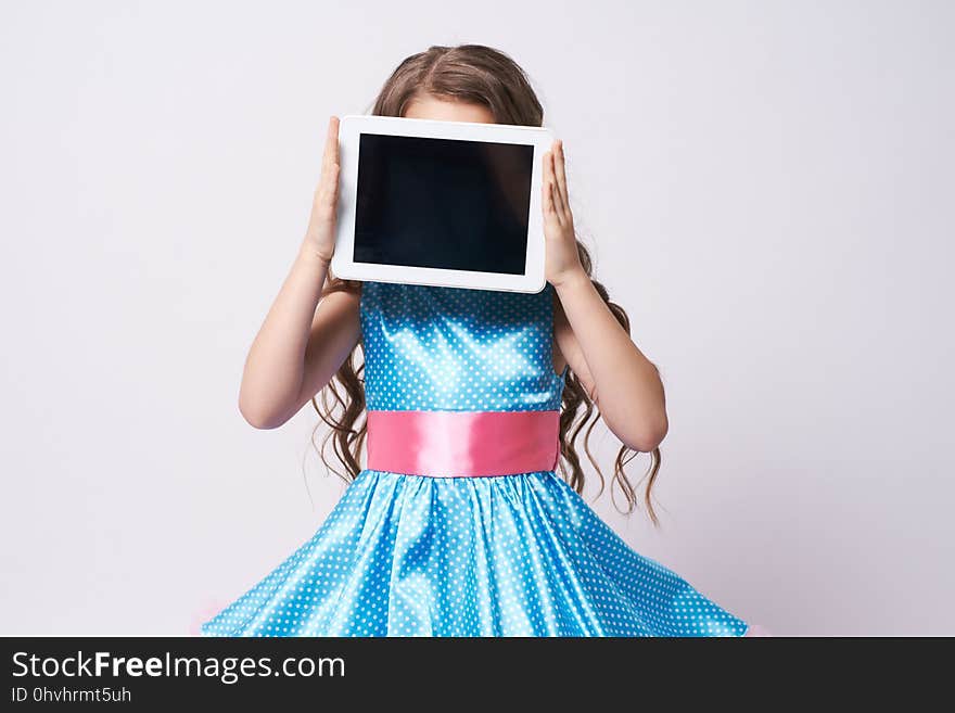 Young Girl with Tablet. Portrait child in blue Dress. Technologies. Young Girl with Tablet. Portrait child in blue Dress. Technologies.