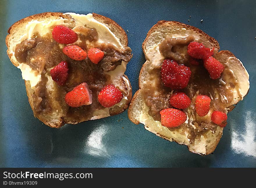 Strawberries picked from the patch this morning atop apple butter made from the tree above, sitting on bread from local market. The margarine though, comes from a giant plastic tub. Strawberries picked from the patch this morning atop apple butter made from the tree above, sitting on bread from local market. The margarine though, comes from a giant plastic tub