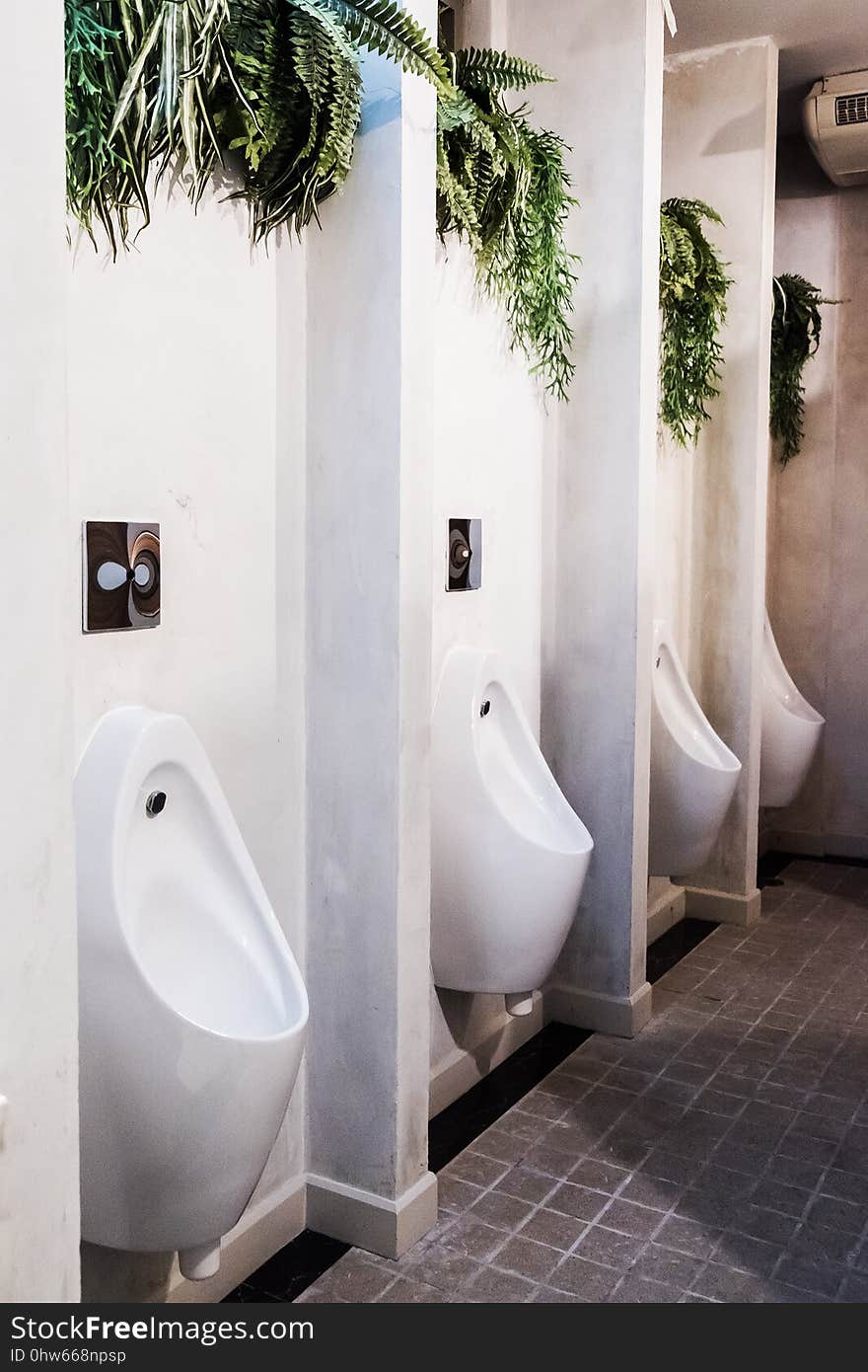 White urinal in men public toilet with black wall tile on backgrold