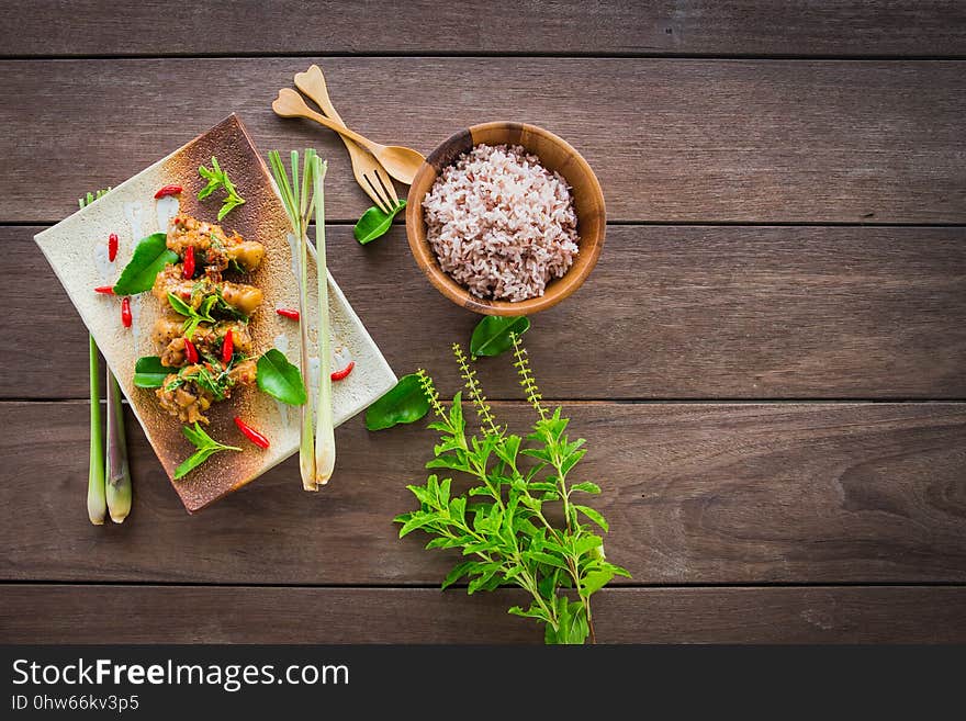 Stir-fried chicken with basil and rice on table