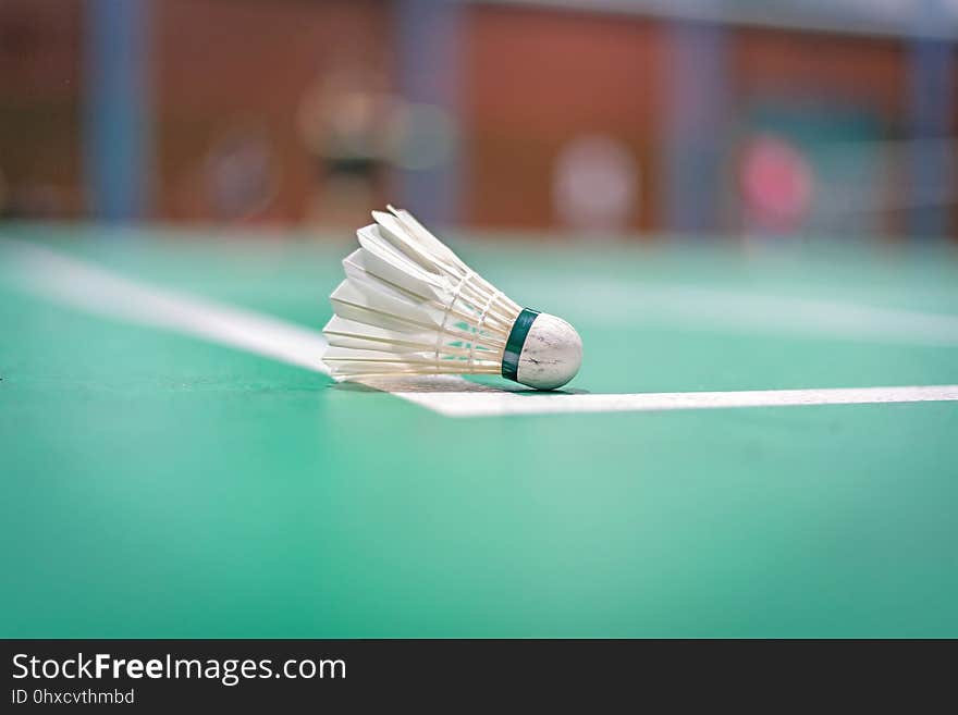 badminton shuttlecock on green court.