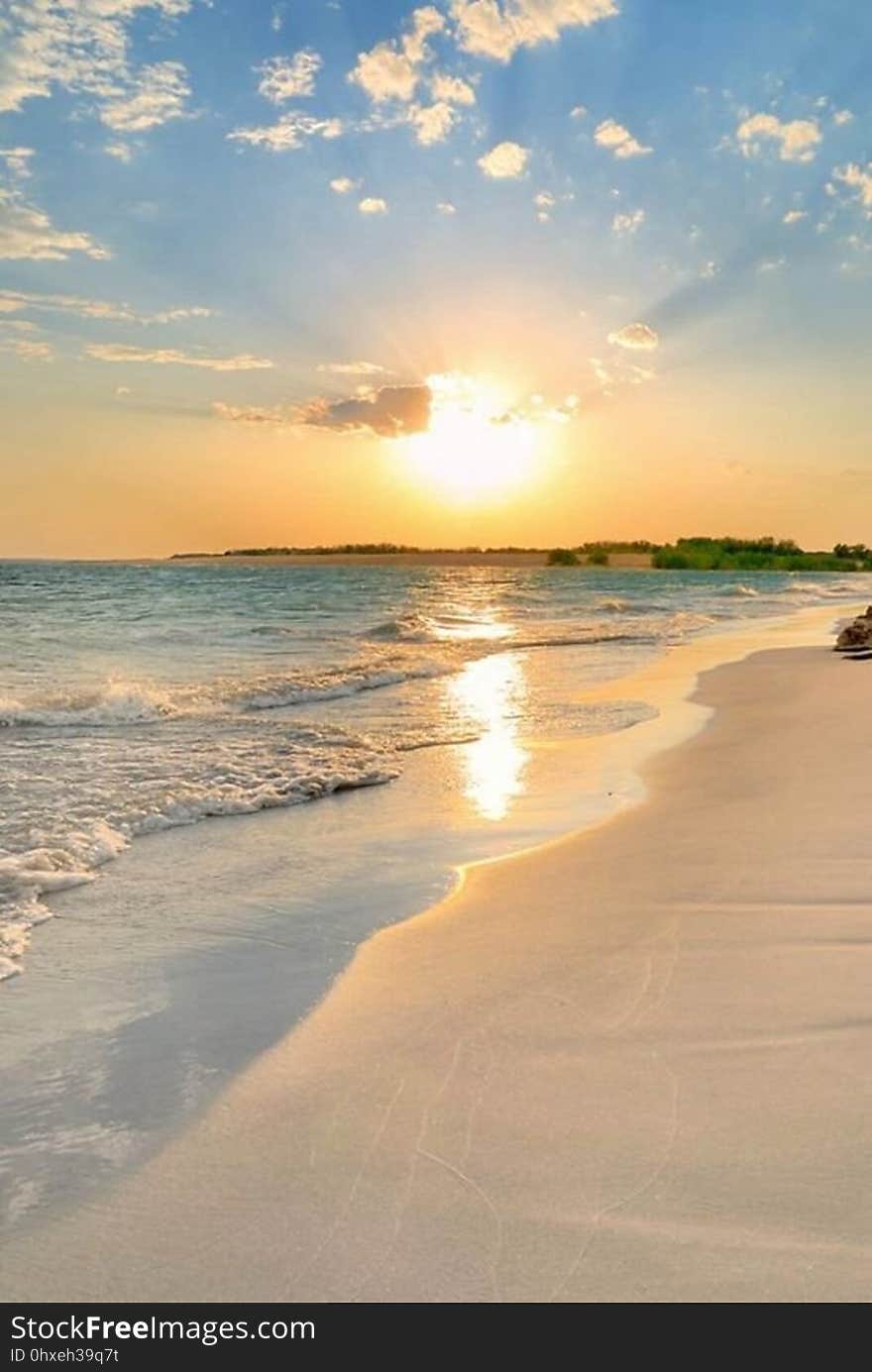 A tranquil beach at sunset.