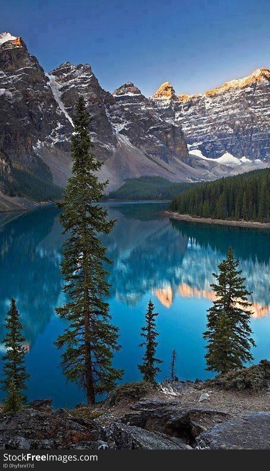 A lake in a mountain valley with the peaks reflecting from the water. A lake in a mountain valley with the peaks reflecting from the water.