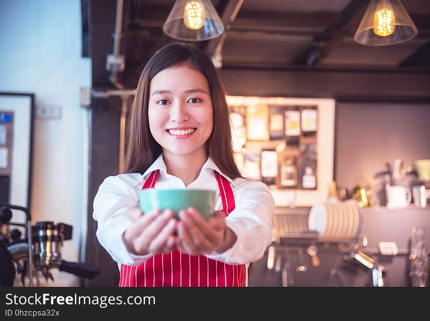 Barista Wearing Red Color Apron Holding Coffee Cup