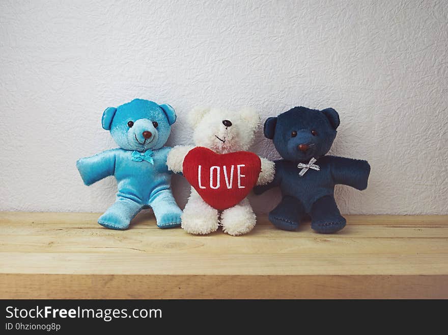 Lovely teddy bear and red heart shape sitting on wood table